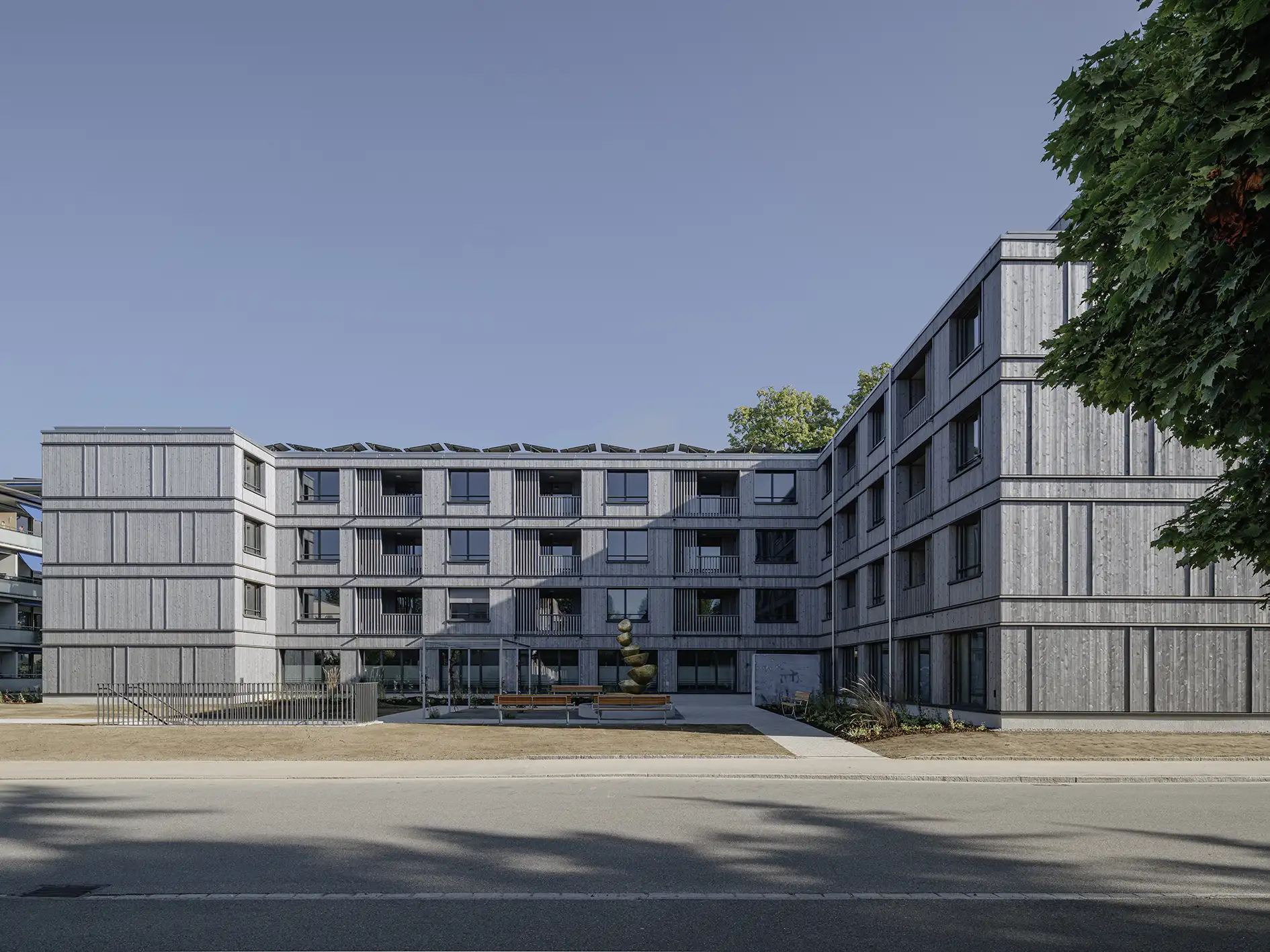 Mehrstöckiges Gebäude mit zahlreichen Fenstern und angrenzendem Parkplatz.